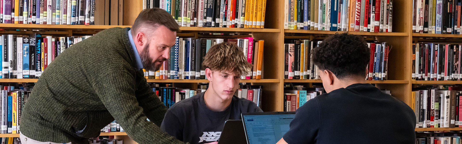 Students working the library with a professor