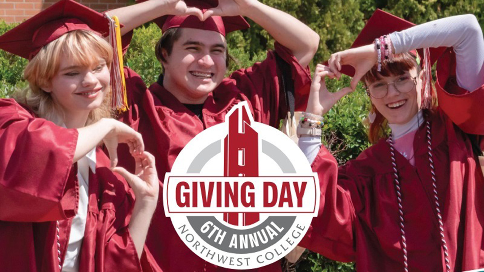 Three students in cap and gown each holding their hands in the shape of heart with a Giving Day logo at the bottom